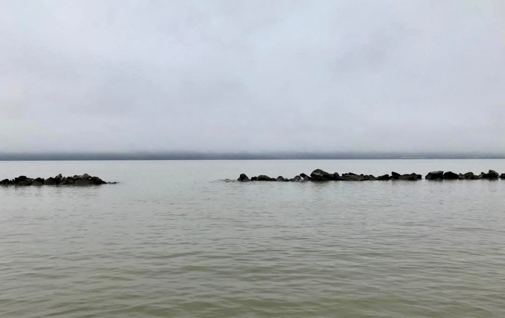 Muted views of the Hudson River with calm water and soft gray sky.