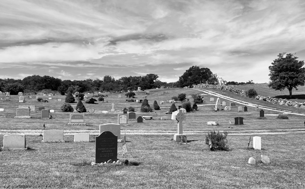 Historic Block Island cemetery in black and white with gravestones and cloudy sky.