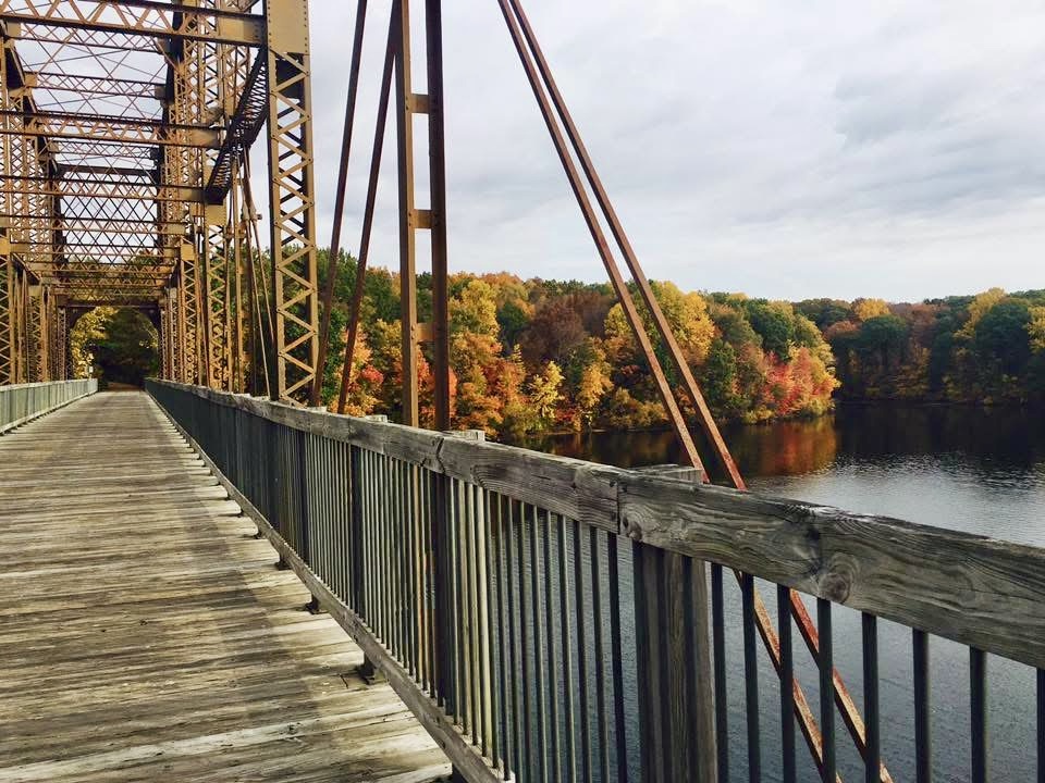 An old rustic railroad bridge that has been converted into a walkway over the Croton reservoir as part of the North County Trailway.