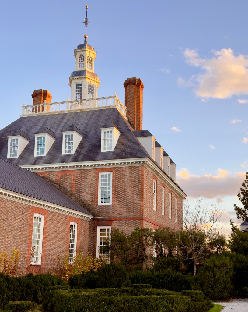 The Governor's Palace at Colonial Williamsburg with the setting sun reflecting off the cupola.