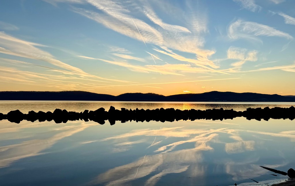Clouds and a blue sky reflecting on a glassy Hudson River at Slack Tide in Croton-on-Hudson, NY